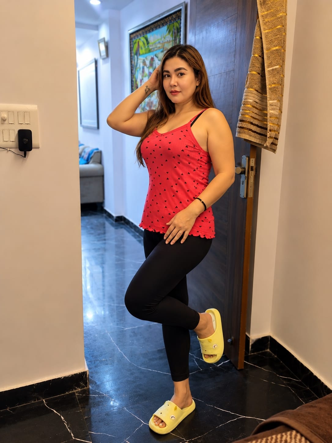 Zarina posing indoors in a red top